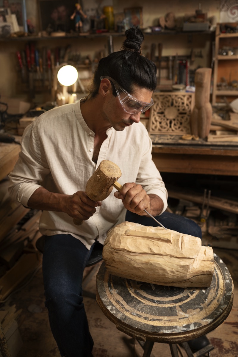 Artesano tallando una pieza de madera en su taller